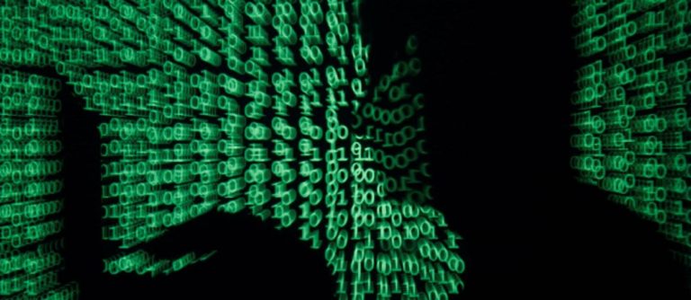 67681796_A-man-holds-a-laptop-computer-as-cyber-code-is-projected-on-him-in-this-illustration-pi